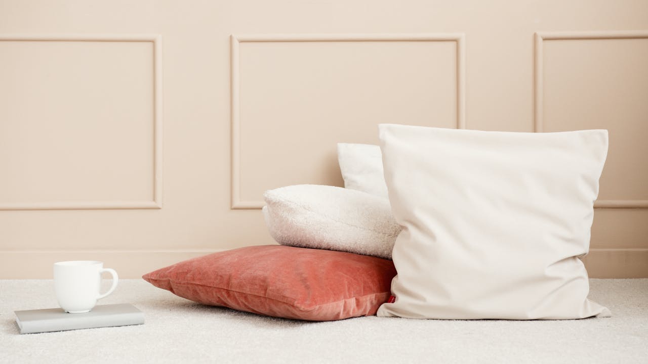 our-story Simple setup with pastel tones and cozy pillows on a soft carpet.