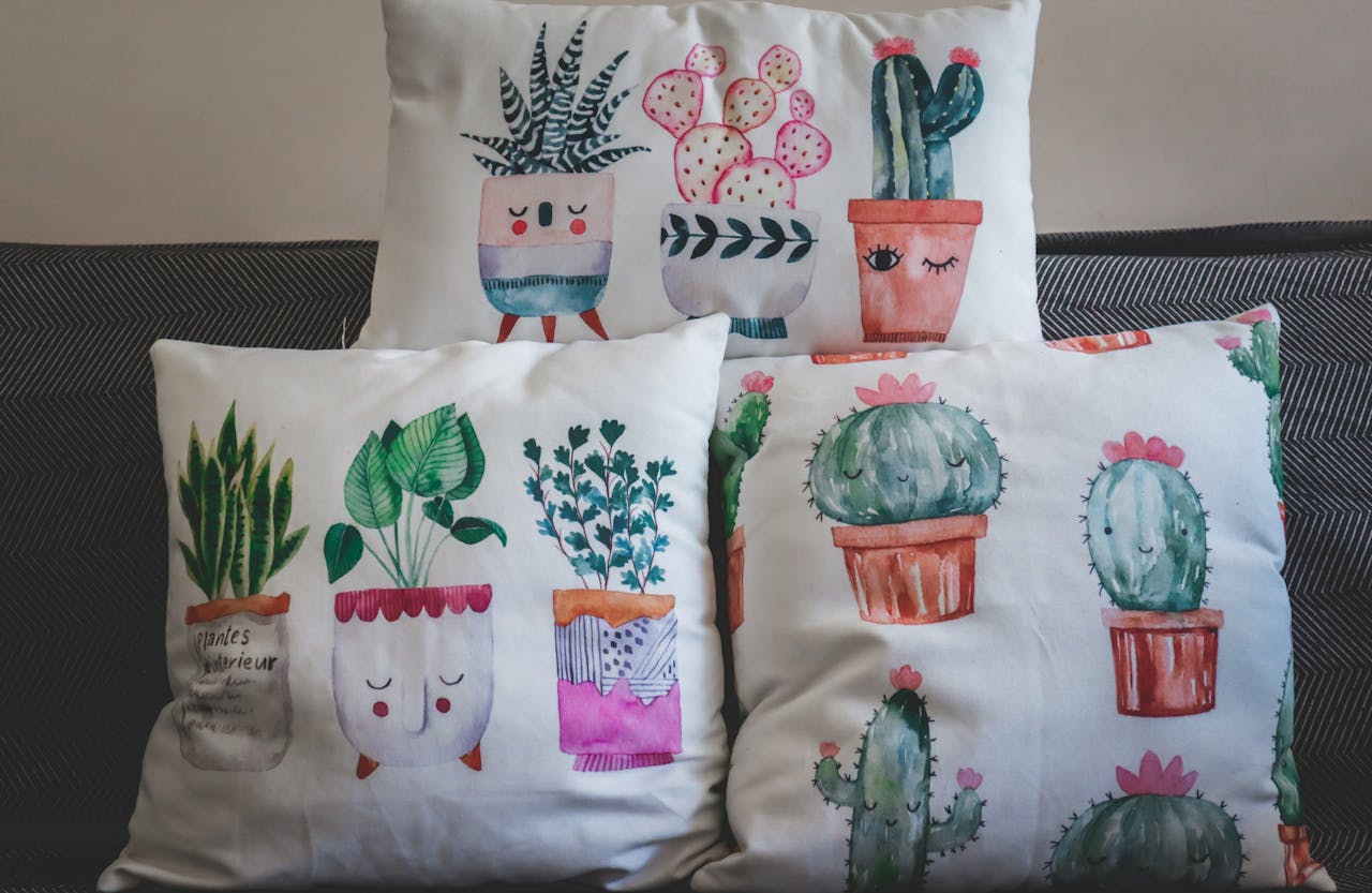 A collection of artistic plant-themed throw pillows on a sofa.